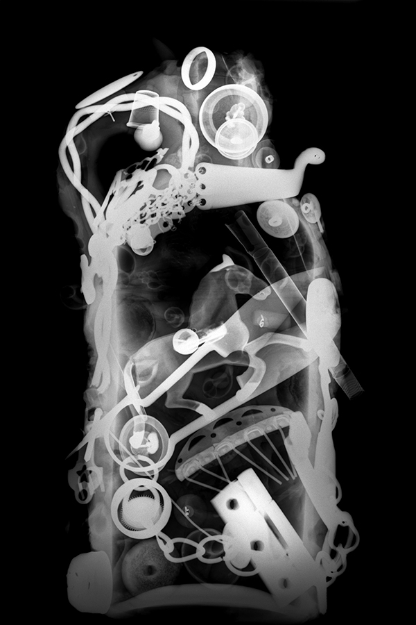 X-ray of jar containing many abstract items. 