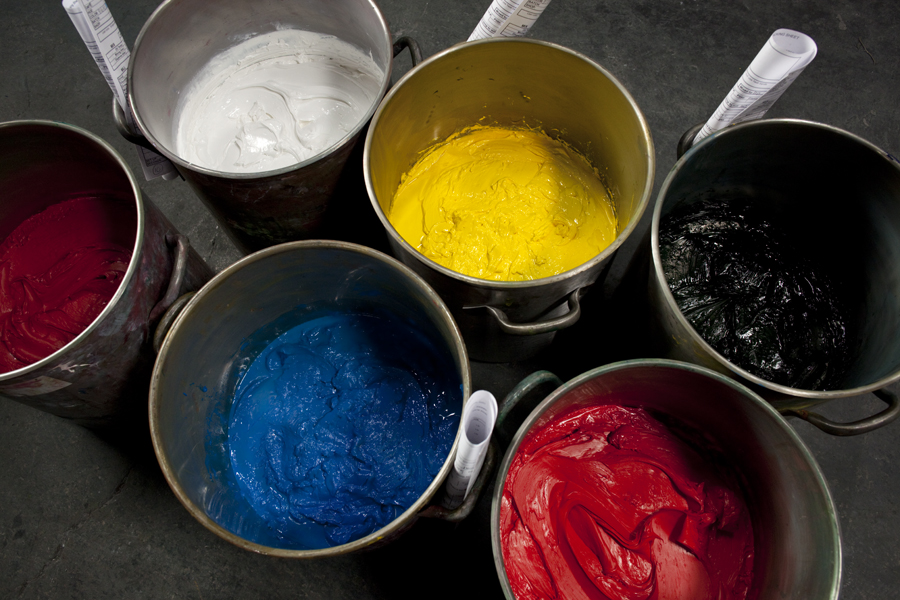 Buckets of red, white, blue, yellow, and black paint. 