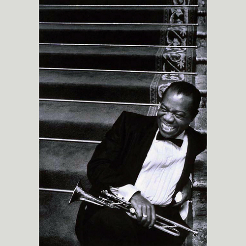 Louis Armstrong sitting on steps with trumpet