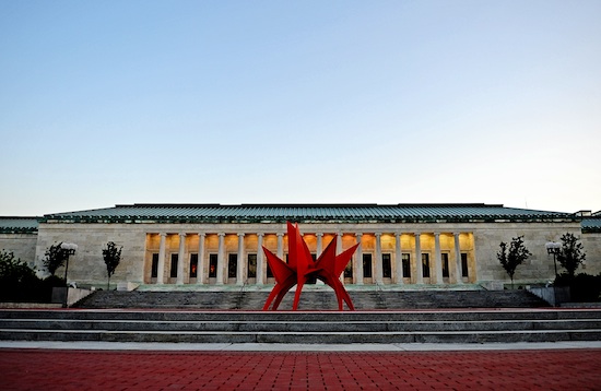 a red Alexander Calder stabile is foregrounded against a classical looking building with terraced steps
