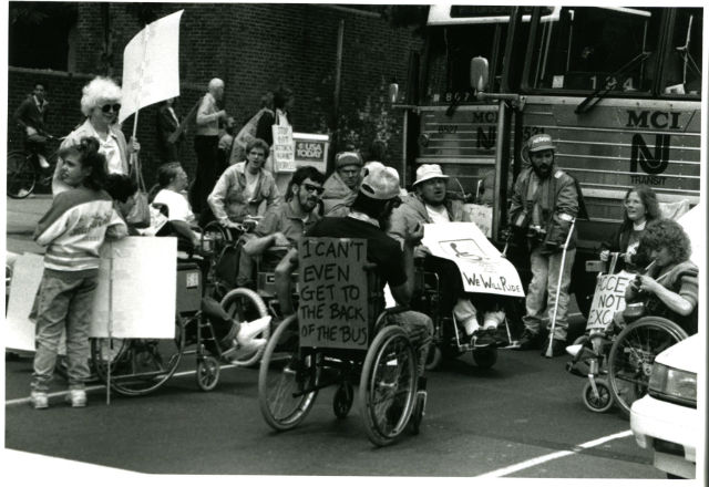 People in wheelchairs with protest signs