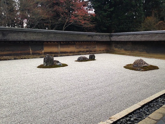 a zen garden with three boulders spaced on a bed of gravel