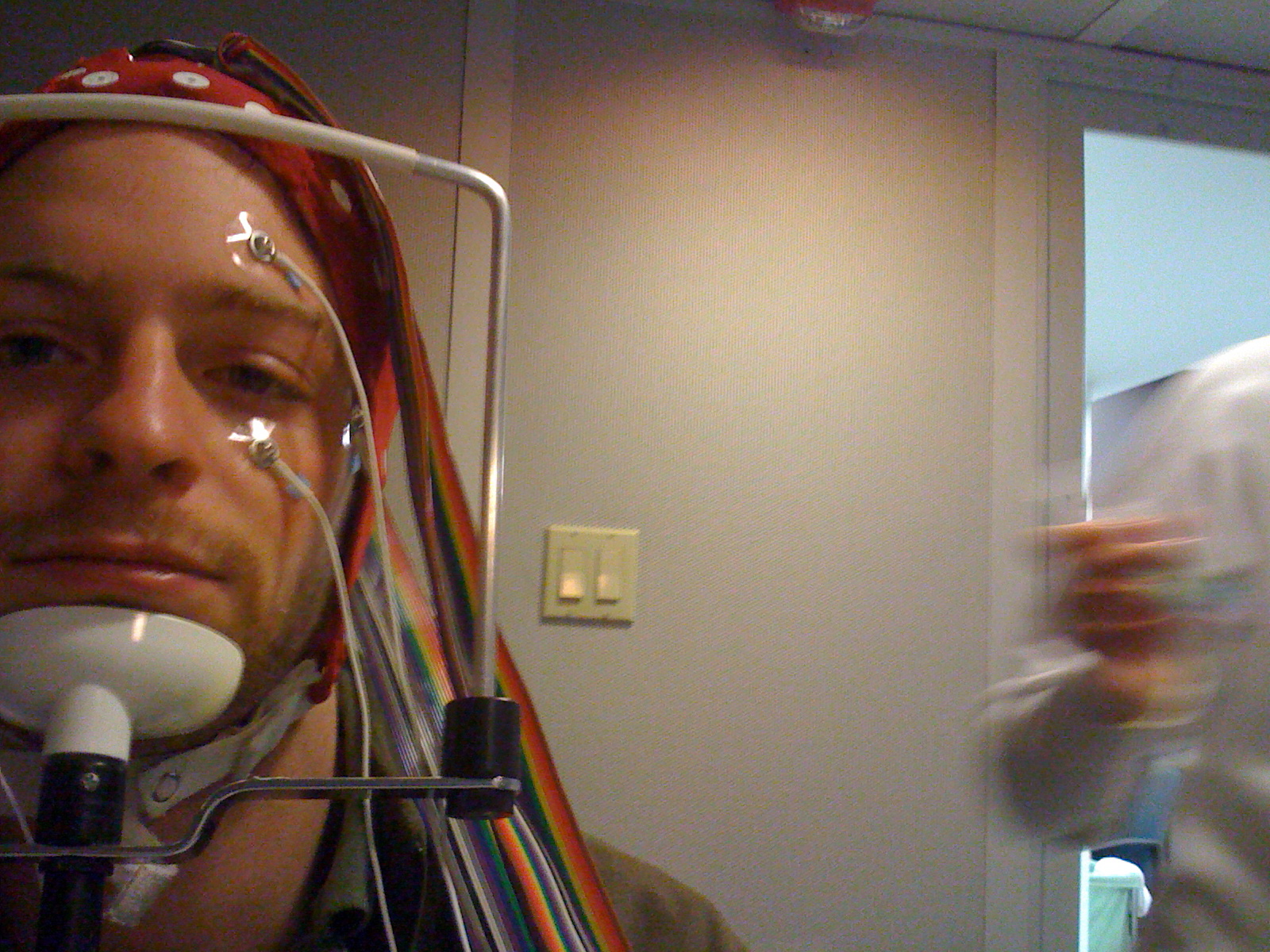 Man with wires connected to his face and head. 