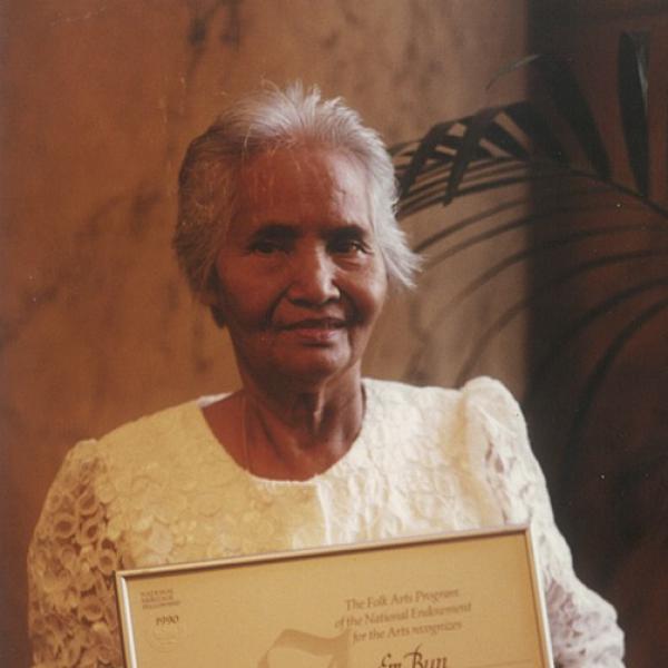 Elderly woman holding a certificate.