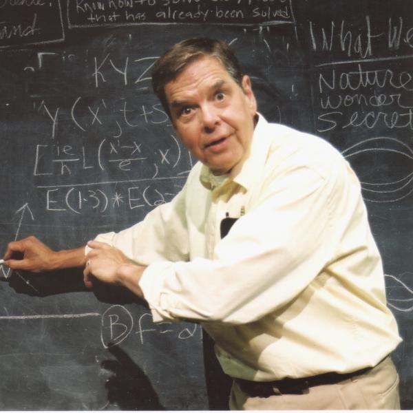 Man standing at chalkboard full of mathematical equations.