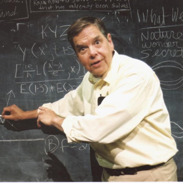 Man standing at chalkboard full of mathematical equations. 
