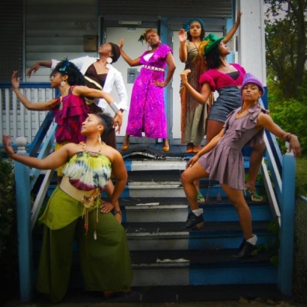 Black women dancers standing on the stairs of a porch.