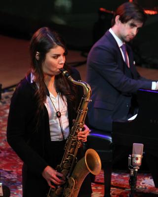 Woman playing saxophone in concert.