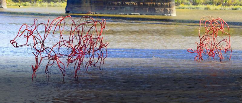 Wiry red sculptures in the river