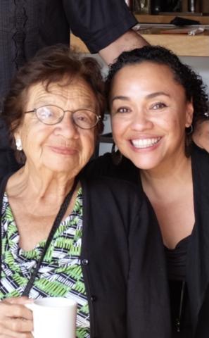 An older woman with glasses and short hair next to a younger woman with hair pulled back smiling. 