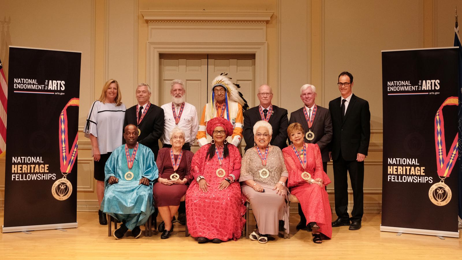 Group of folk artists posing for photo with NEA chairman at left and Folk Arts Director at right. 