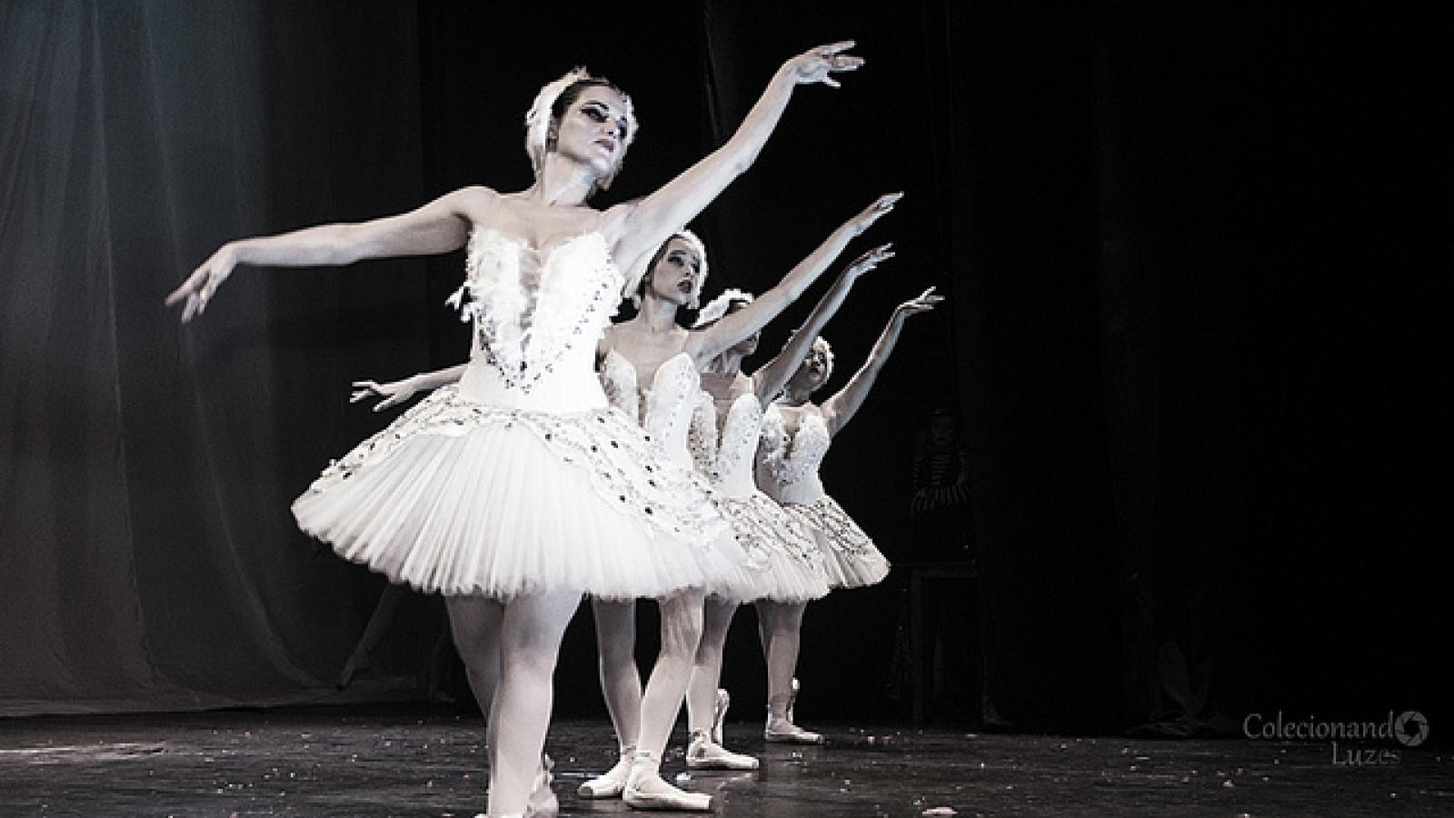 Ballet dancers in a line with arms extended