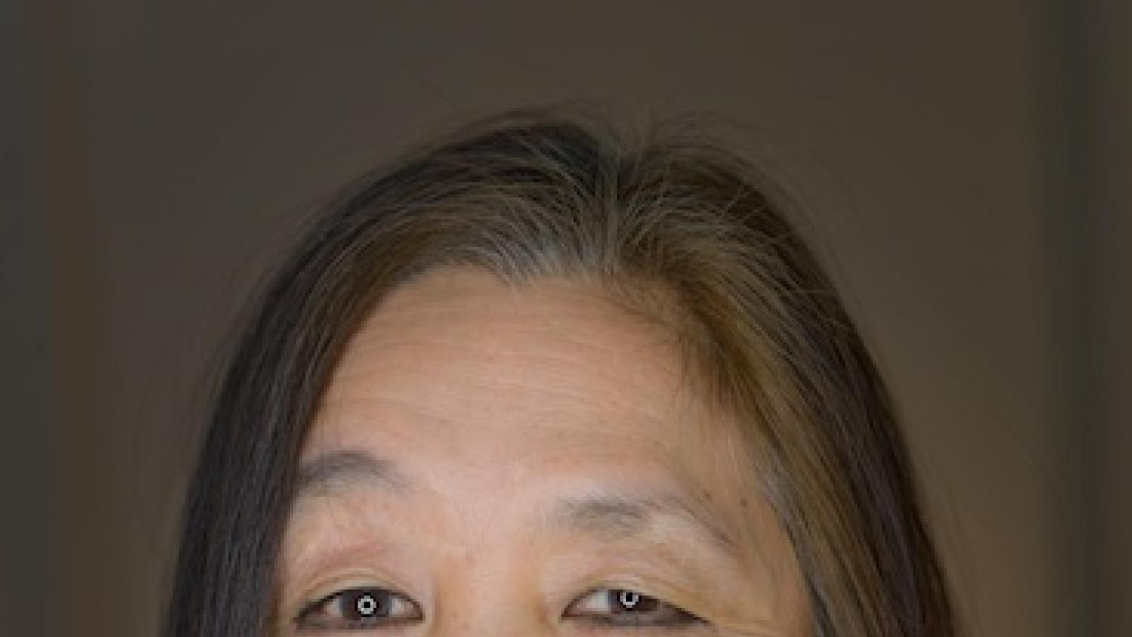 an older Asian-American woman with long dark hair and bright pink lipstick