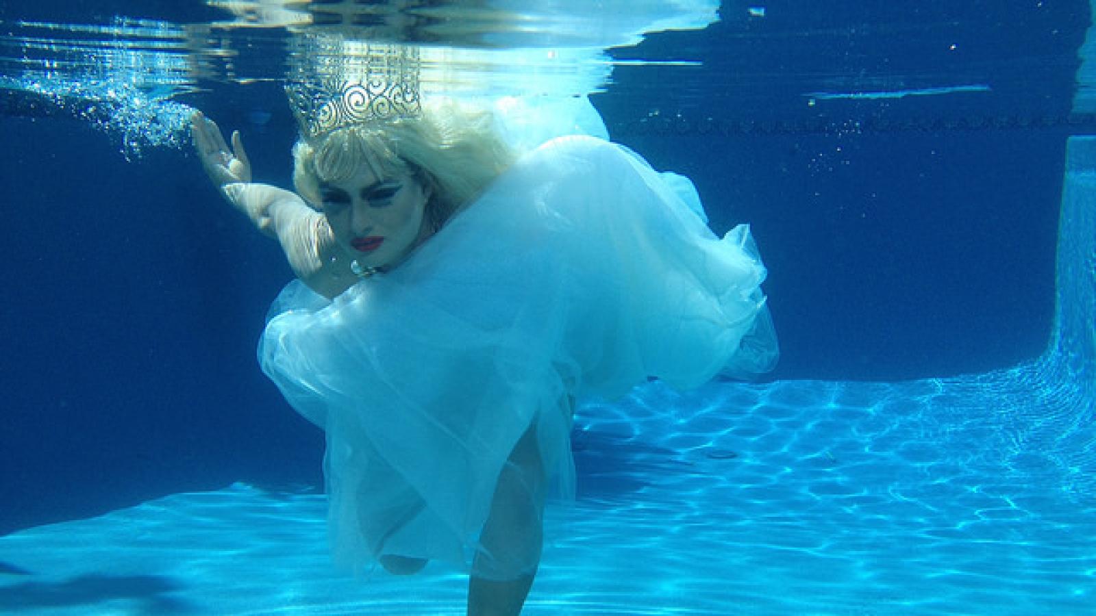 Drag queen in wedding dress underwater