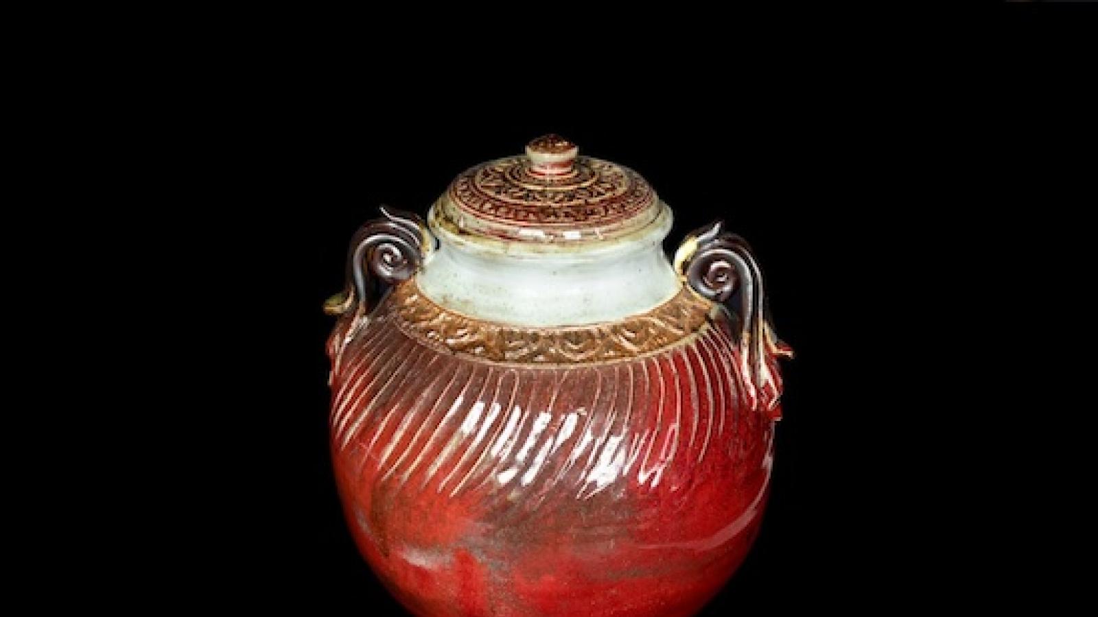 an oxblood red large covered ceramic vessel