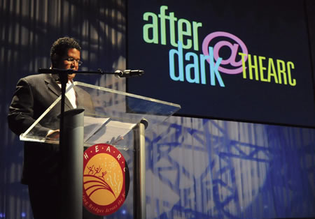 Edmund Fleet a the podium with the words after dark at THEARC projected to his side