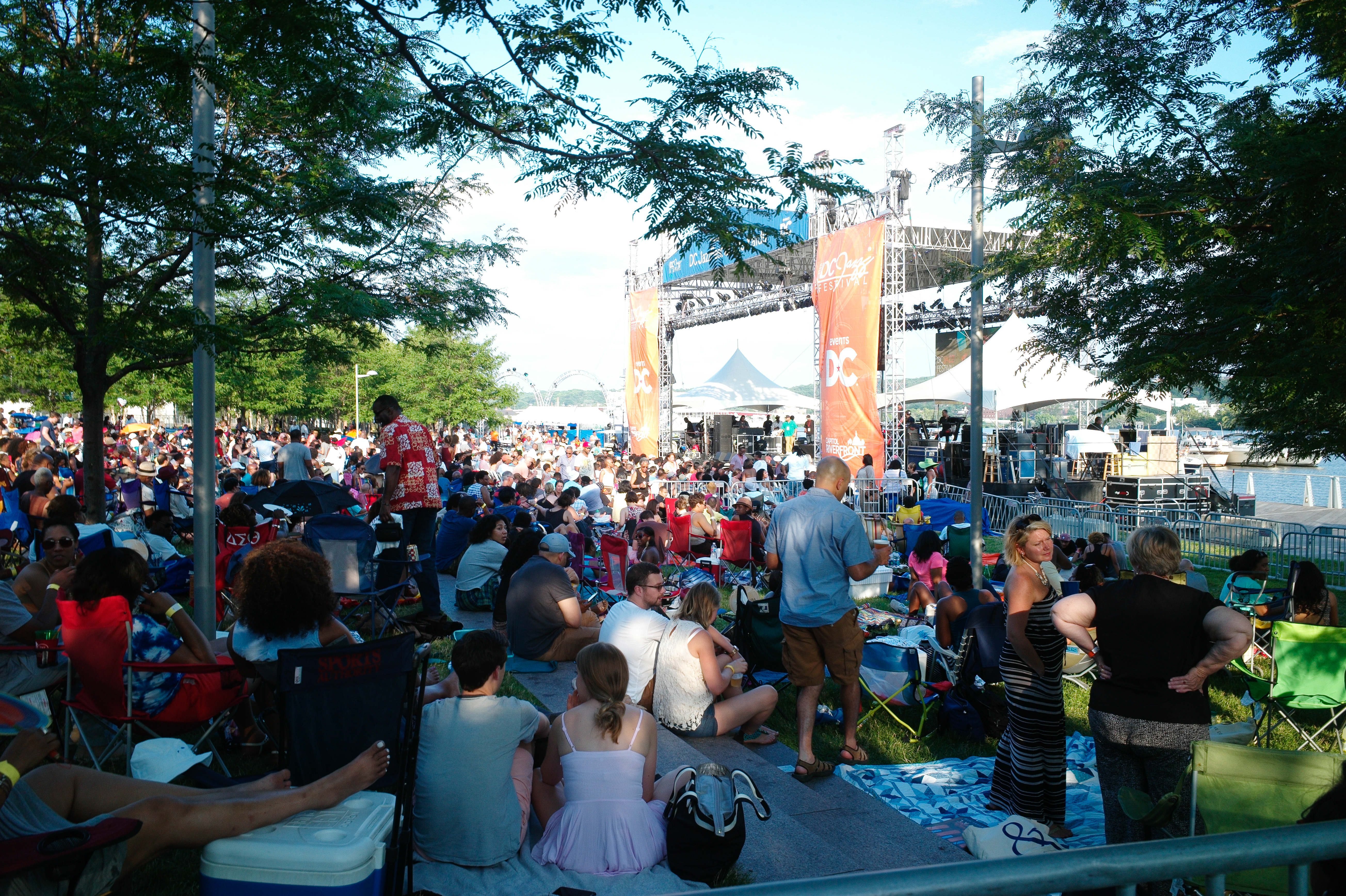 Crowd gathering around an outdoor stage as they enjoy the festival. 