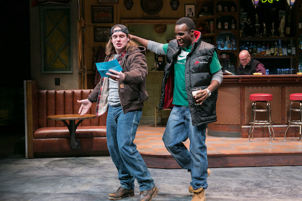 in a production of the play Sweat a young white man reads a letter he holds in his hand to a young black man about to put his arm around his shoulder