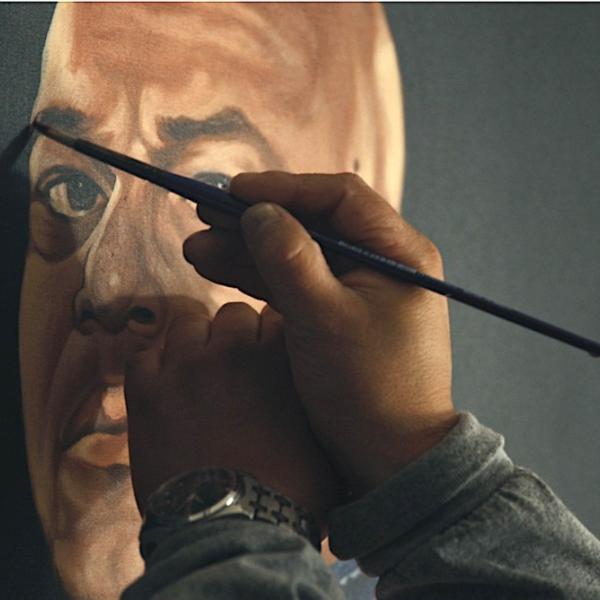 Close up of a hand with a brush working on the face in a portrait