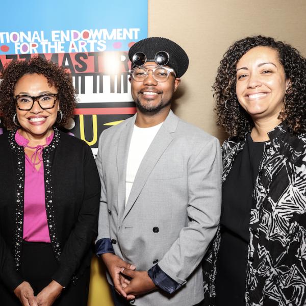 photo of three women and one man standing in front of NEA Jazz Masters signage