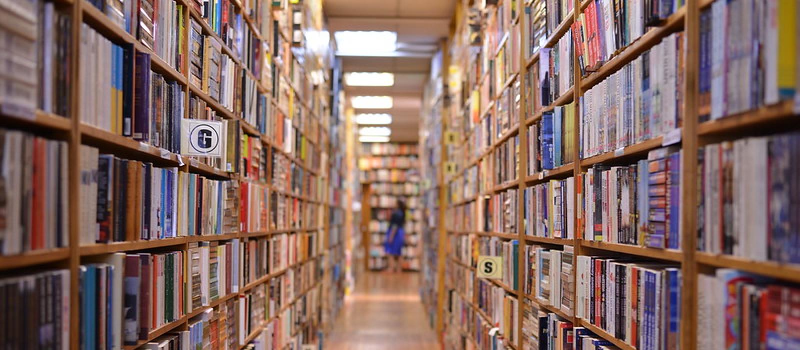 A photo that looks down the aisle of shelves in a bookstore