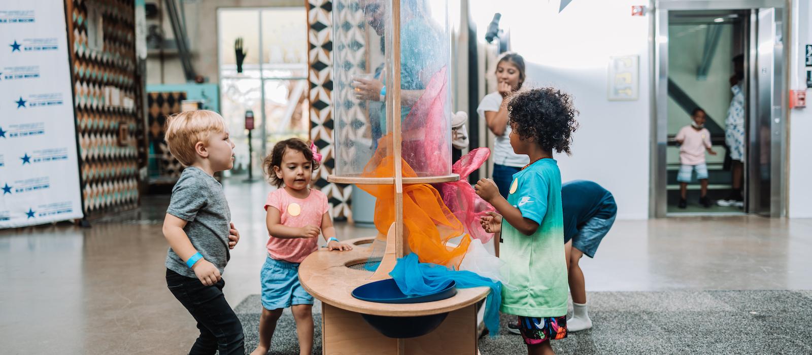 Children playing on an exhibit floor.