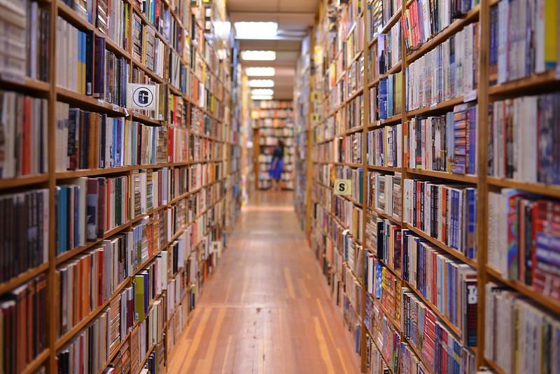 A photo that looks down the aisle of shelves in a bookstore