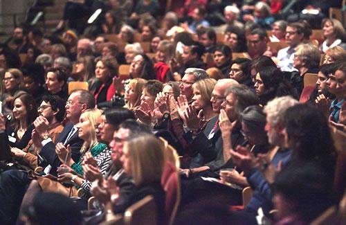 A packed audience, applauding