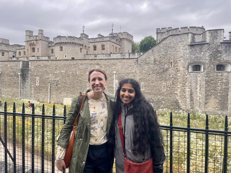 A white woman and young Indian woman pose in front of the Tower of London