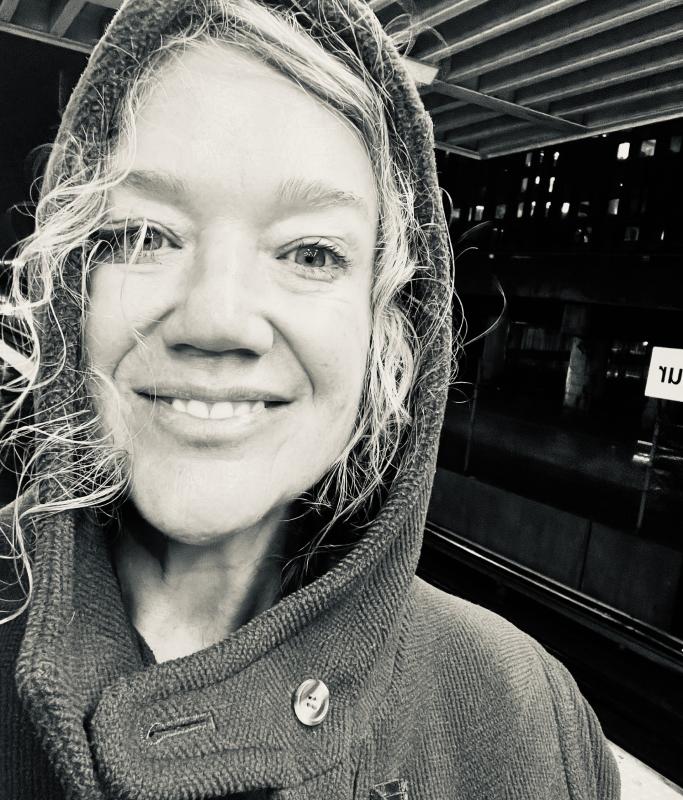 a smiling middle-aged blonde woman with curly hair