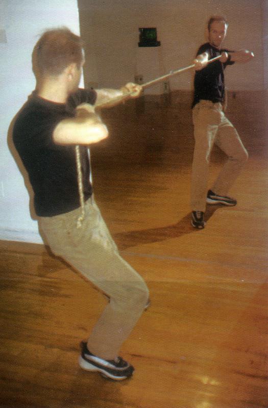 a photograph of a man playing tug of war with a mirror image of himself