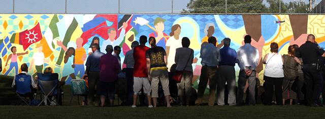 Local crowd standing in front of the new mural