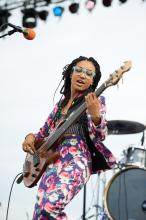 Esperanza Spalding playing the guitar on-stage.