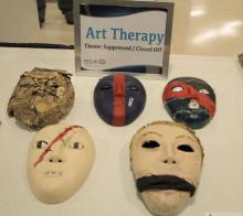 papier mache masks made in art therapy displayed on a table at a Walter Reed event