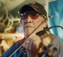 Close-up of Trimble Gilbert playing the fiddle