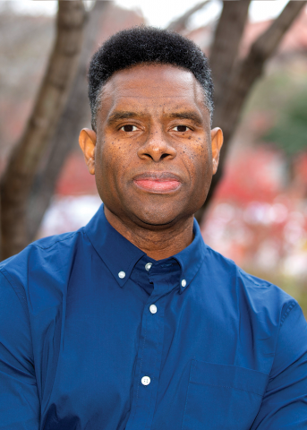 Portrait of Black man in front of a tree.