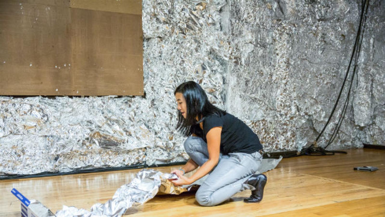 Woman kneeling on floor with tin foil