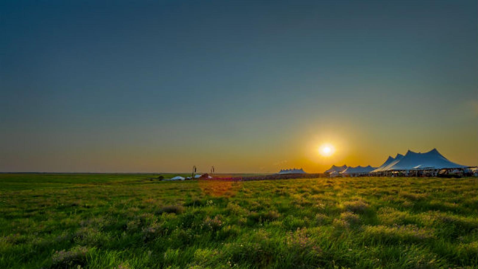 White tents at sunsets in middle of Kansas grassland prairie