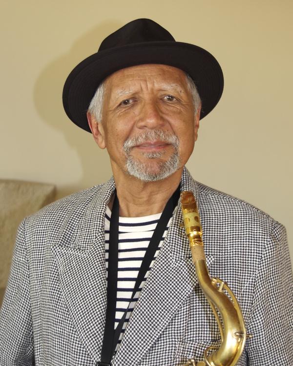 Man in hat holding saxophone.