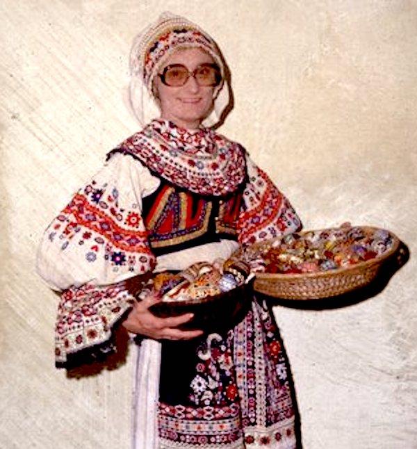A woman in traditional dress holding a basket.