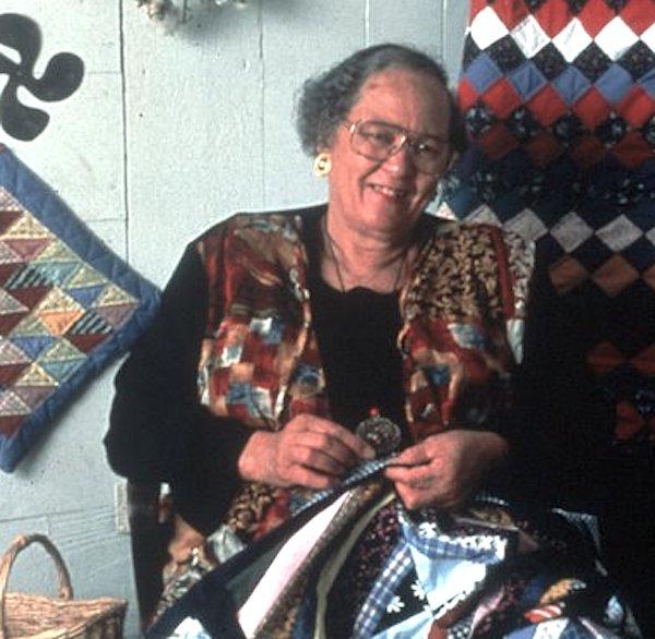 A woman sowing a quilt.