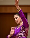 Indian American woman in purple outfit dancing. 